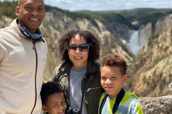 a young boy standing in front of a mountain