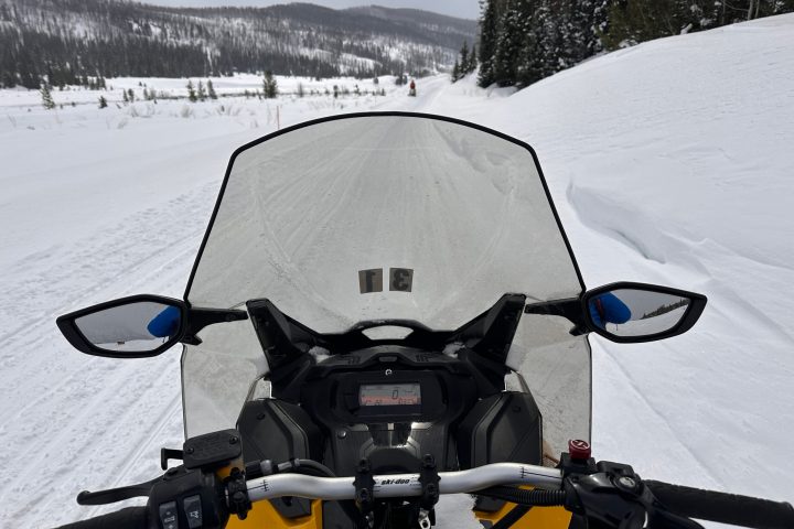 a person sitting on top of a snow covered slope