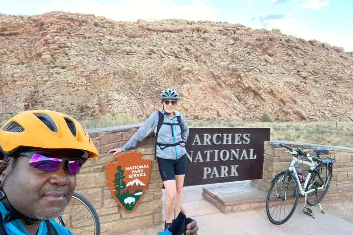 a man with a bicycle in front of a mountain
