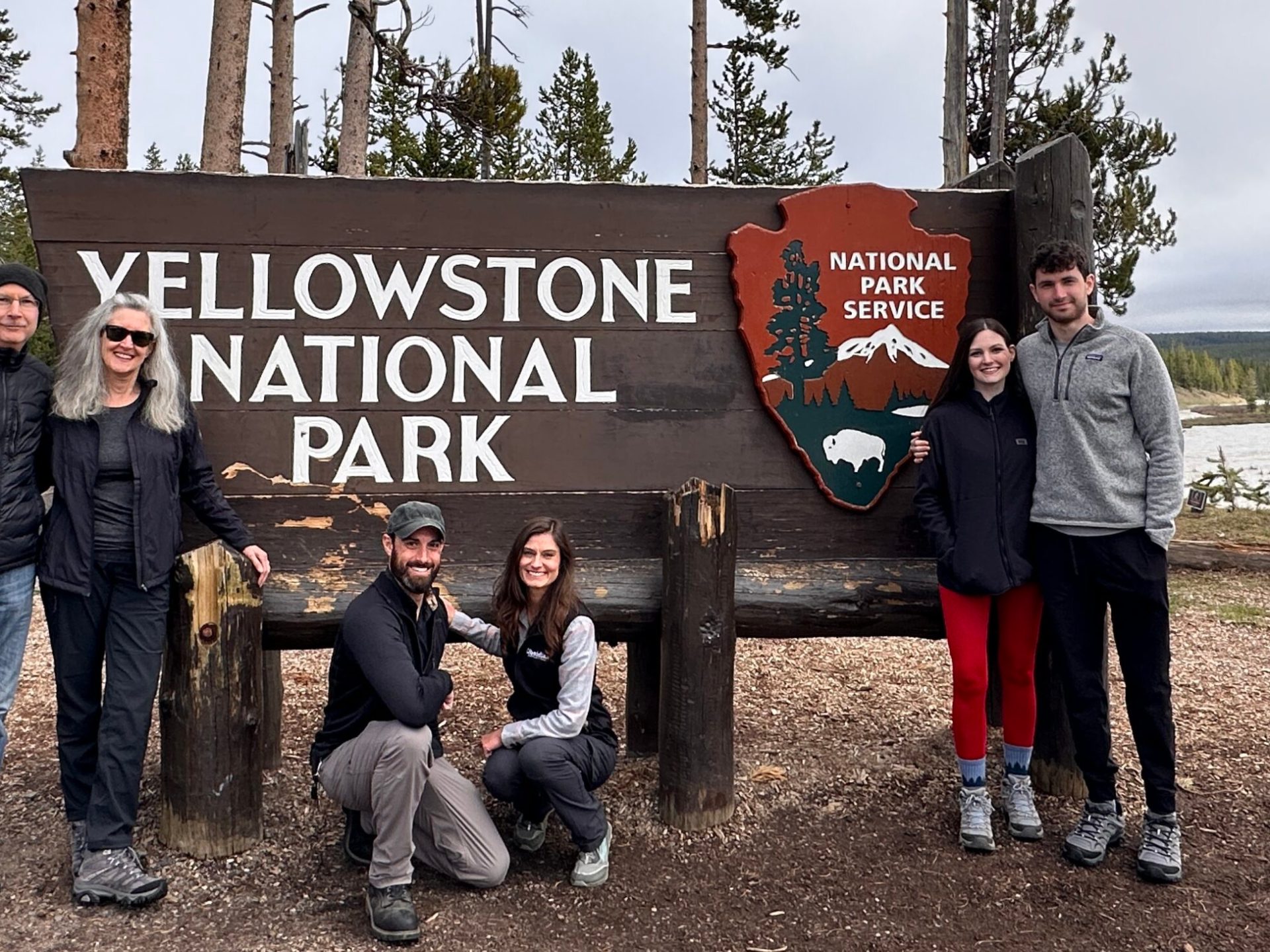 a group of people standing in front of a sign posing for the camera