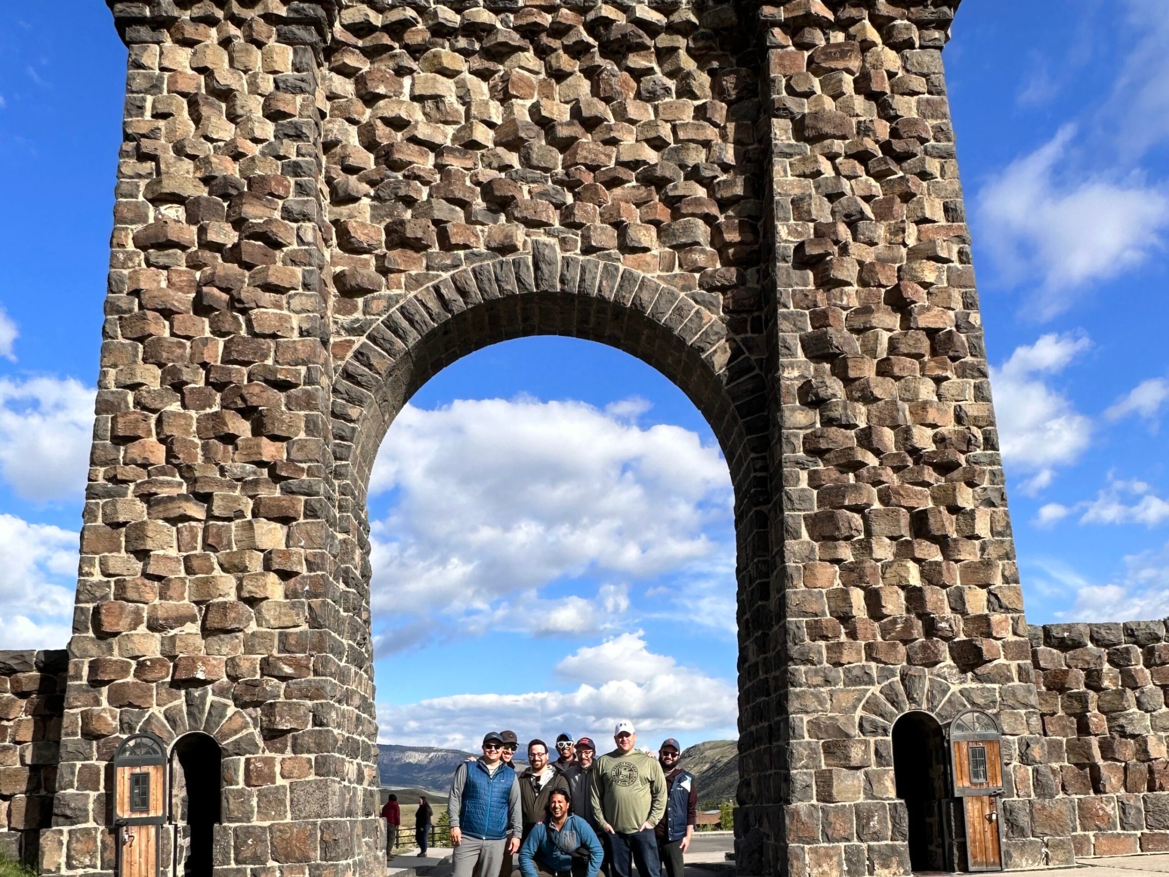 a group of people standing in front of a stone building