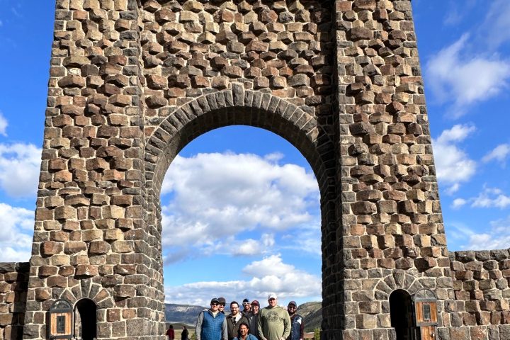 a group of people standing in front of a stone building