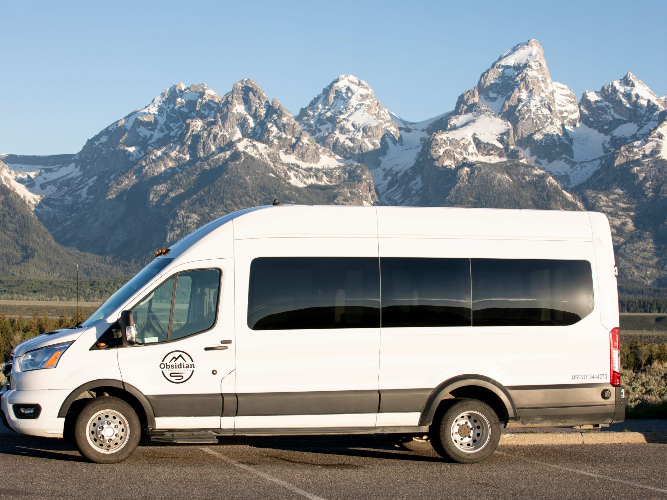 AWD Ford Transit Van parking in front of the Teton Mountain Range