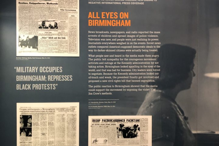 Historical exhibit on Birmingham protest media coverage with newspaper clippings and quotes.