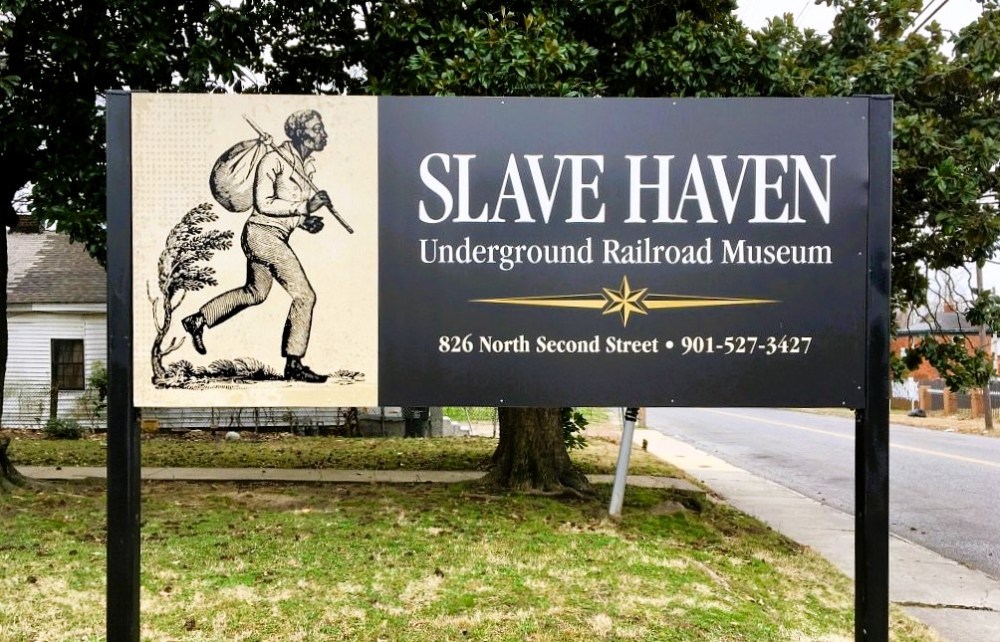 Sign for Slave Haven Underground Railroad Museum with illustration of a man carrying a sack.